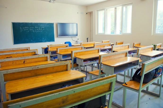 A classroom filled with wooden desks and chairs